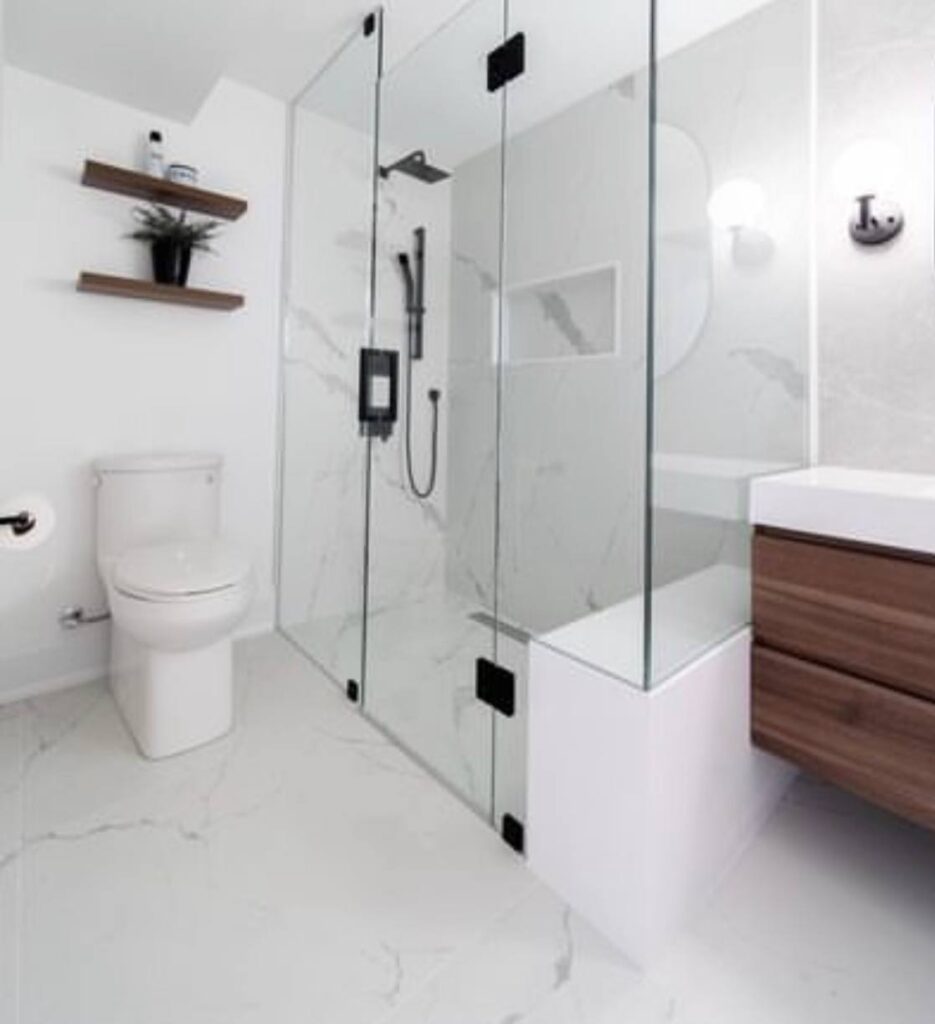Frameless glass walk-in shower beside a floating walnut vanity
