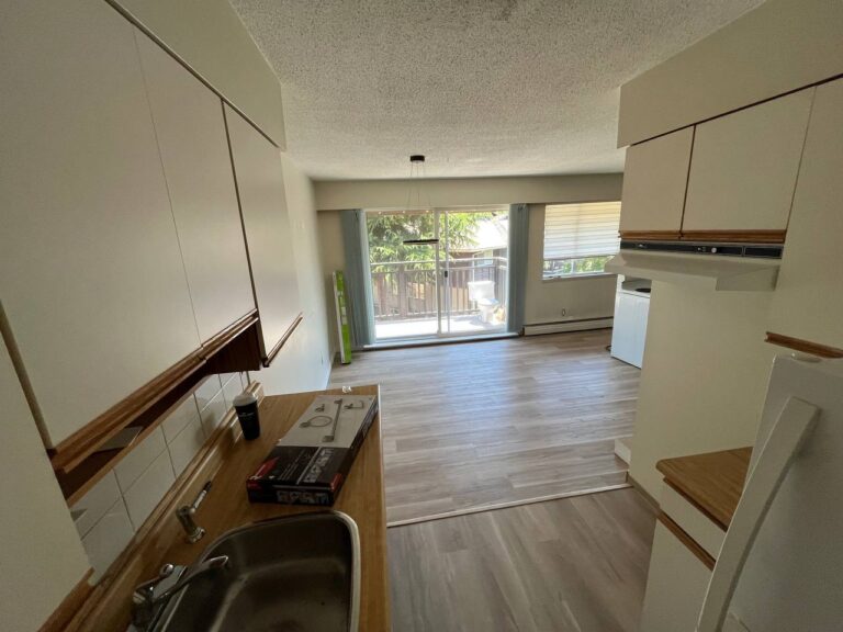 Kitchen during renovation with new flooring leading to the patio