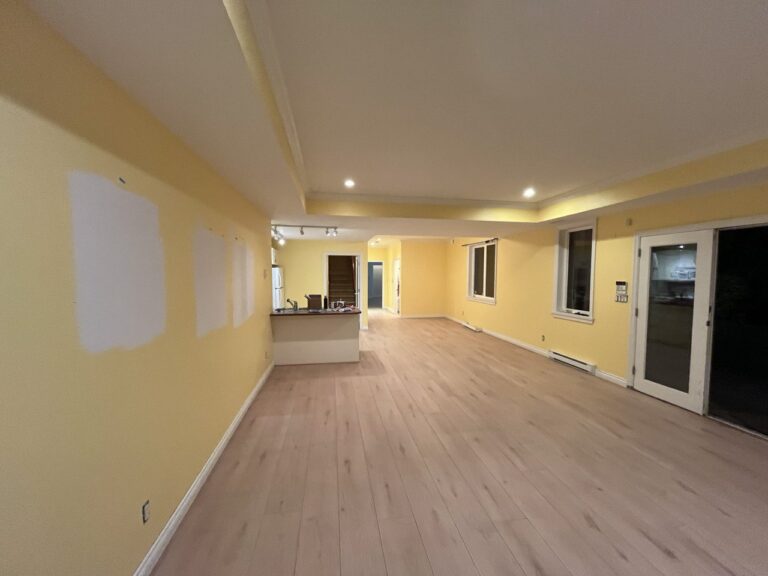 Long open main floor with light oak flooring and pot lights