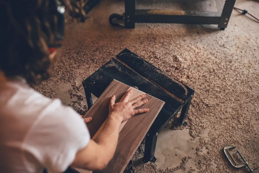 Woodworker handling cabinet-grade plywood in a workshop