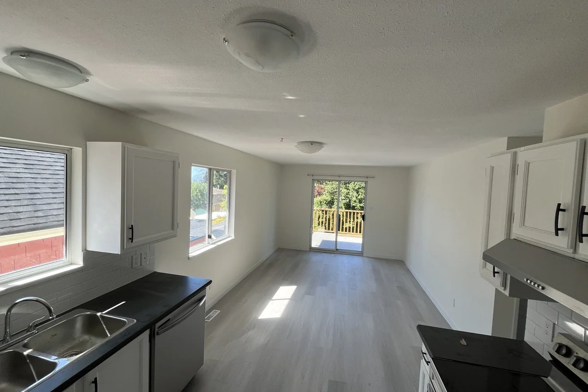 Newly built suite kitchen with white cabinets and vinyl plank flooring