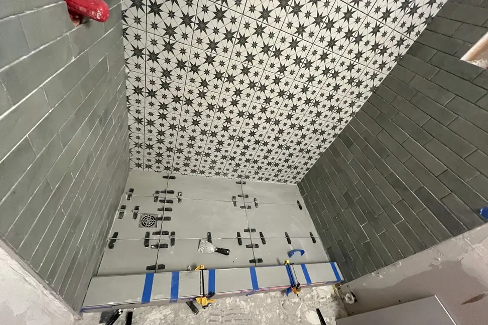 Bathroom tile being installed with levelling clips during a renovation