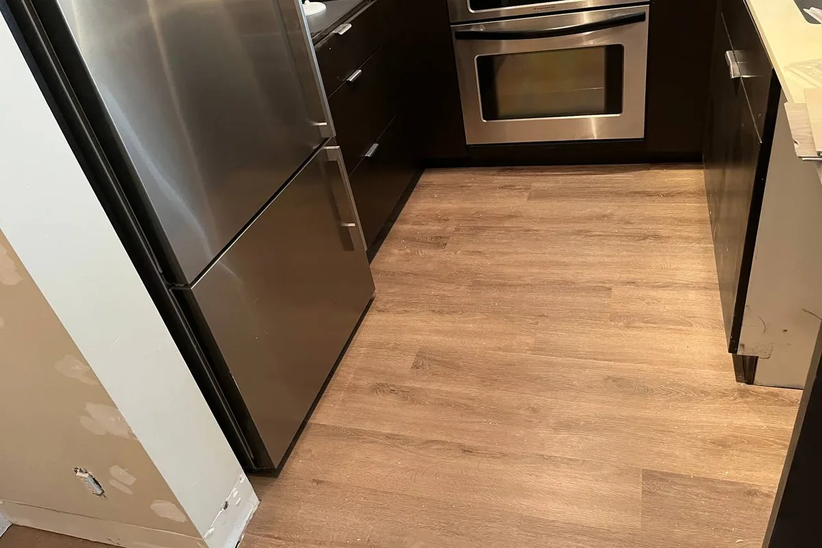 Condo kitchen with stainless steel appliances and new wood-look flooring