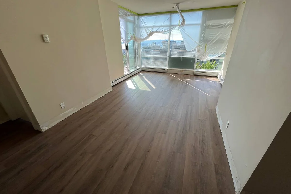 Condo living room with newly installed dark wood-look flooring