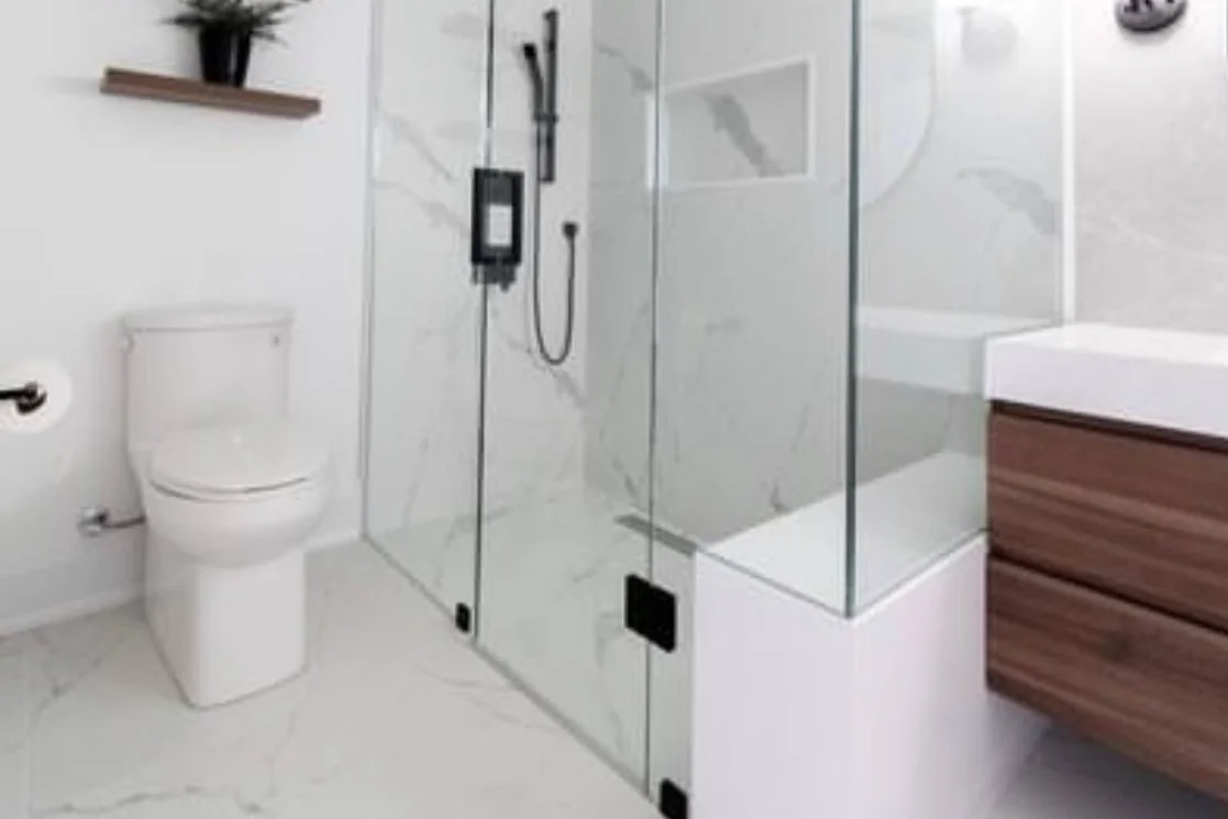 Frameless glass shower with black hardware and marble-look tile