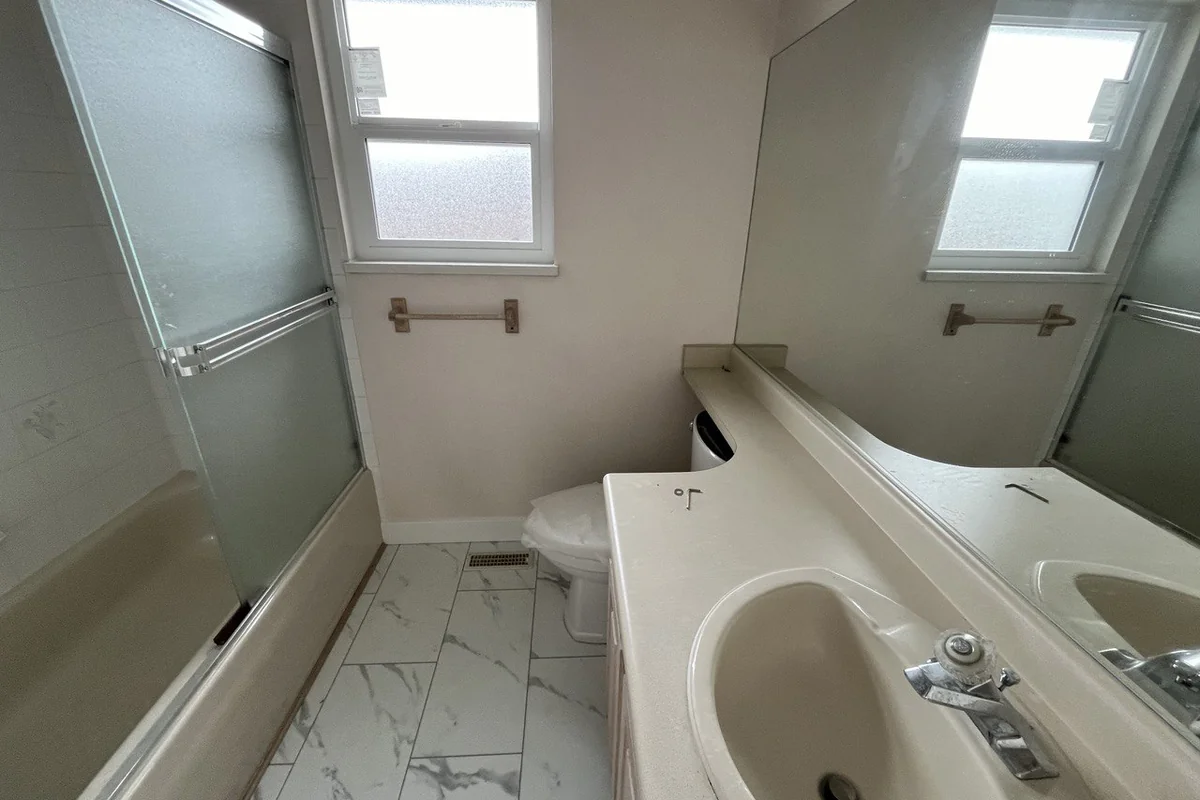 Bathroom with marble-look tile flooring, a tub and a vanity