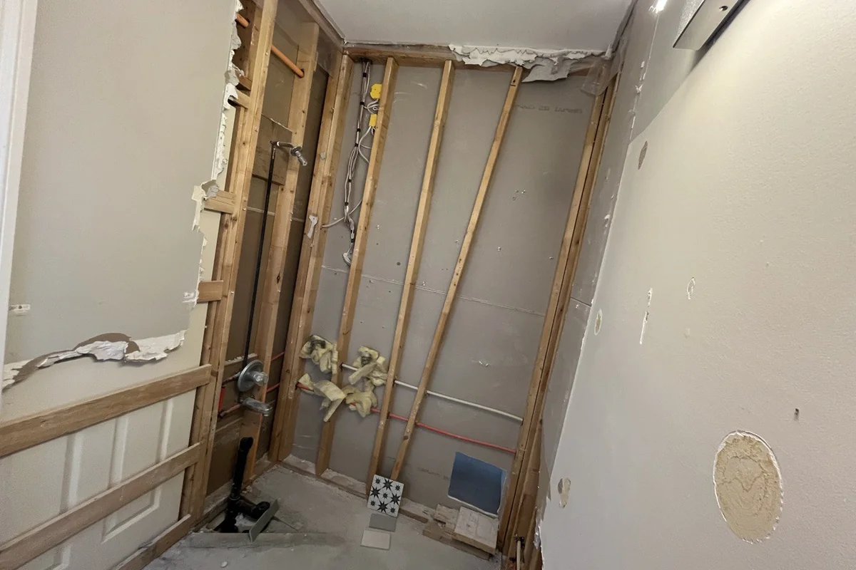Walls opened during a renovation, exposing old framing and plumbing