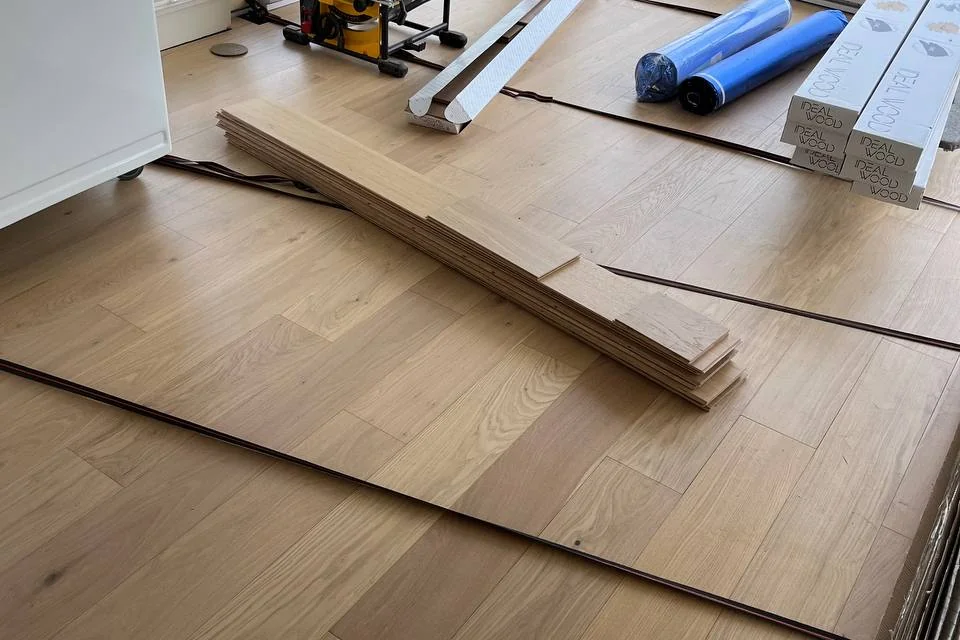 Wide wood flooring planks being installed in a condo